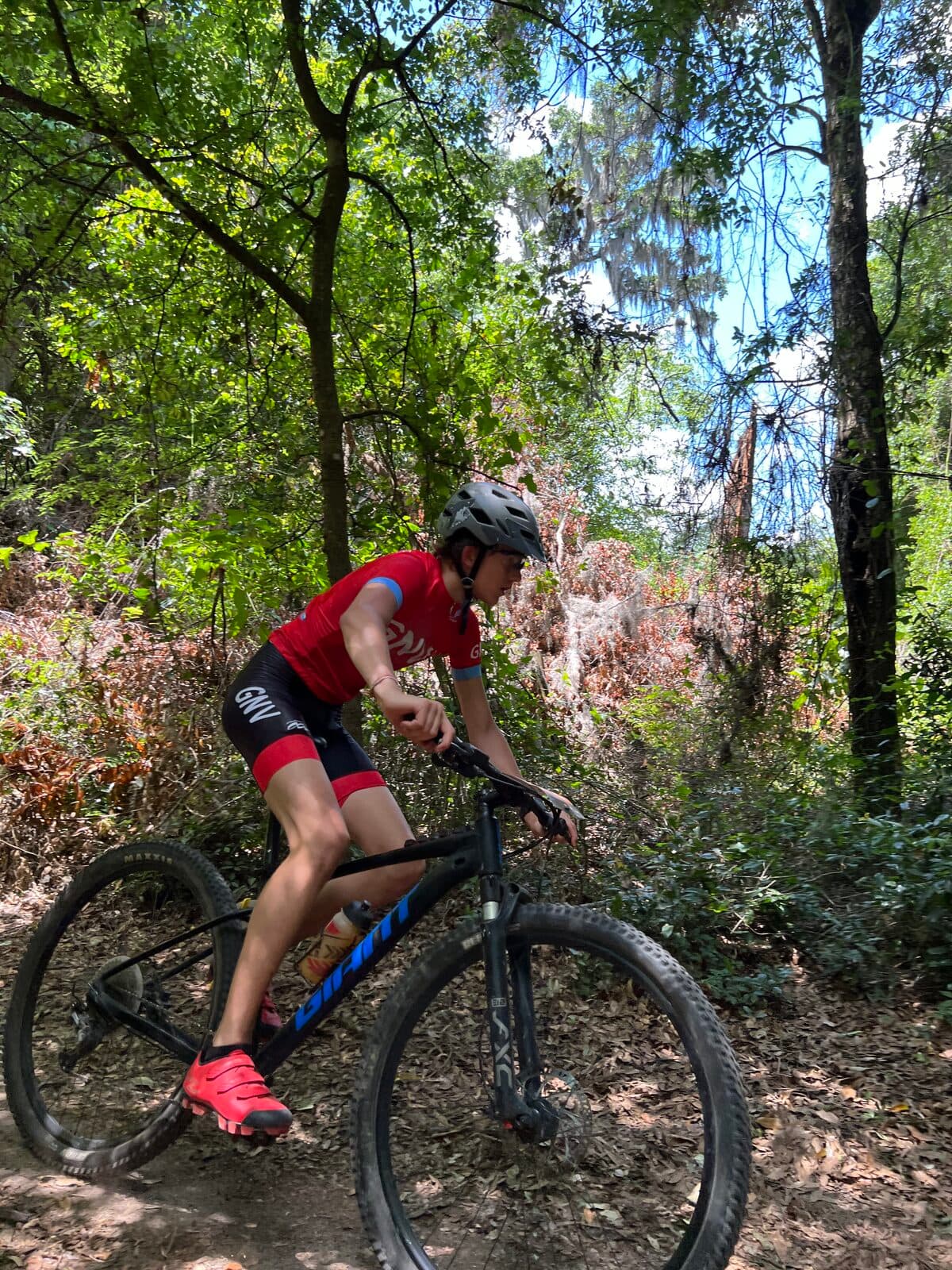 Olen Lokkesmoe mountain biking on a wooded singletrack trail